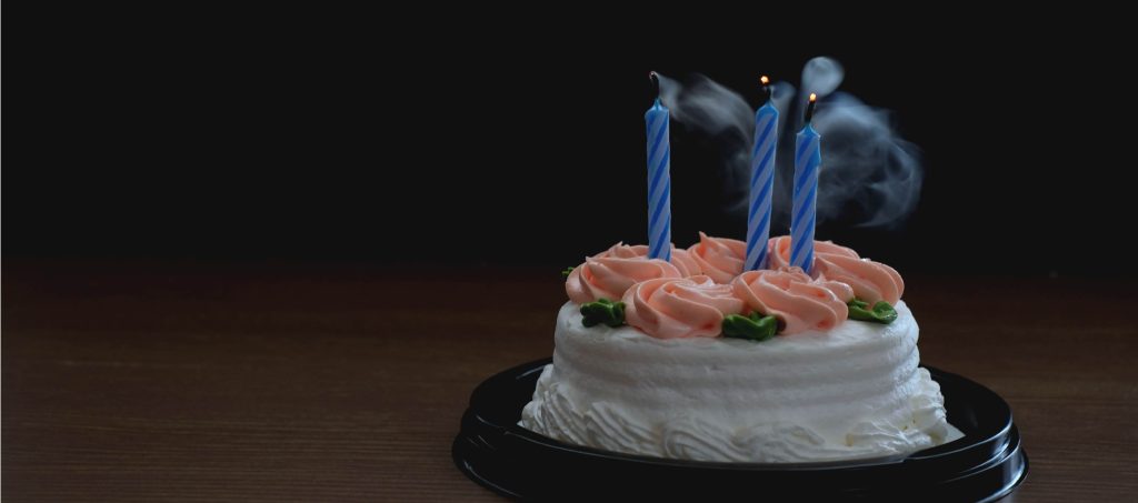 Picture shows birthday cake with candles blown out. This blog discusses how to celebrate meaningful days while grieving