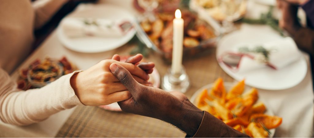 holding hands at thanksgiving table gratefulness and grieving